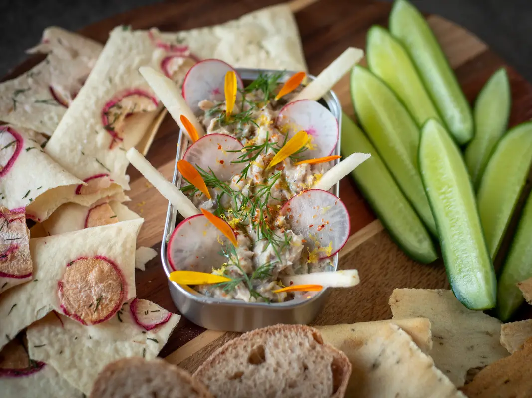 Rilettes van sardines geserveerd met crackers, brood en verse groenten